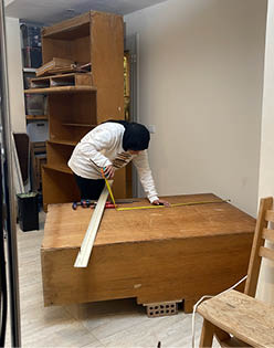 A person is standing on a step ladder. Description generated by AI