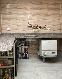 A kitchen with a sink and a refrigerator. Description generated by AI